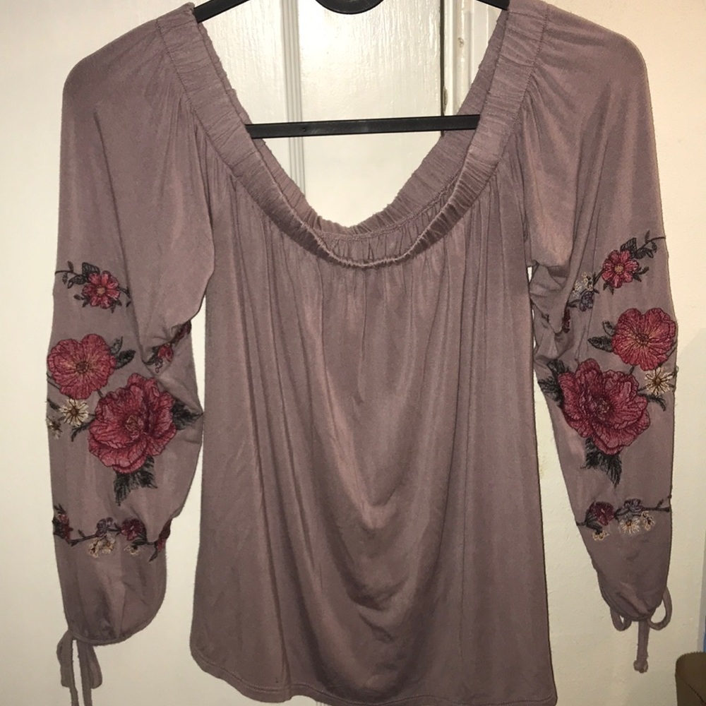 Purple top with flower stitching on the arms